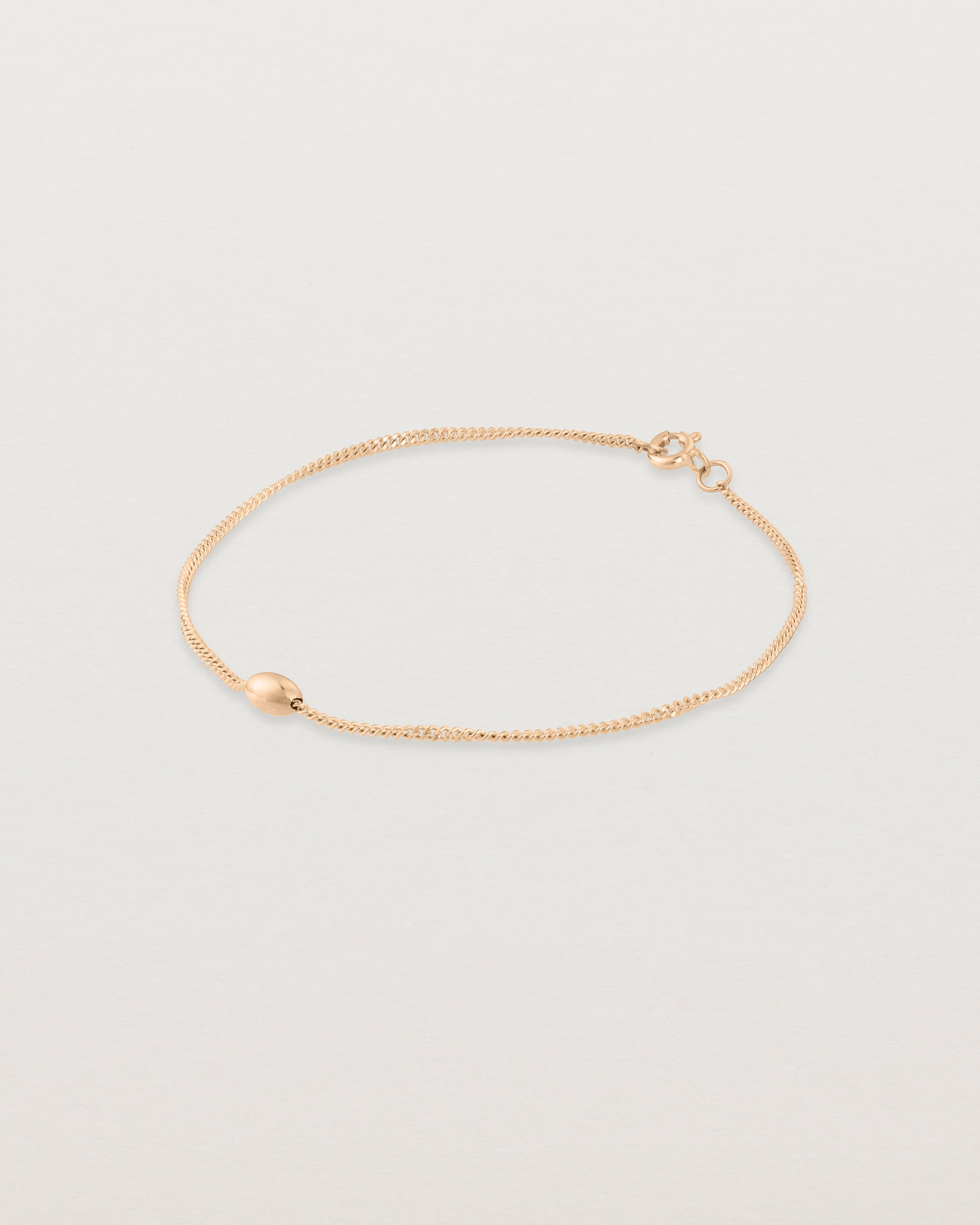 Side view of Sonder bracelet in rose gold showing one charm
