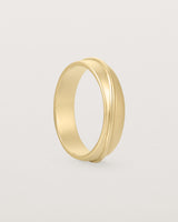 Angled view of the Surge Wedding Ring | 5mm | Yellow Gold.