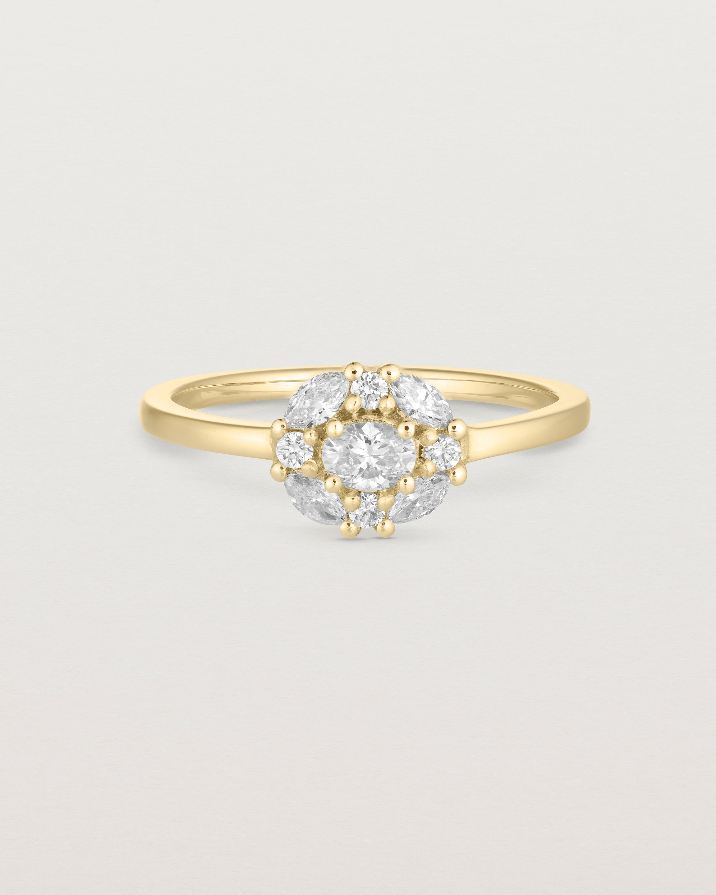 deep etched image of a yellow gold engagement ring with an oval white diamond and a halo of eight diamonds.