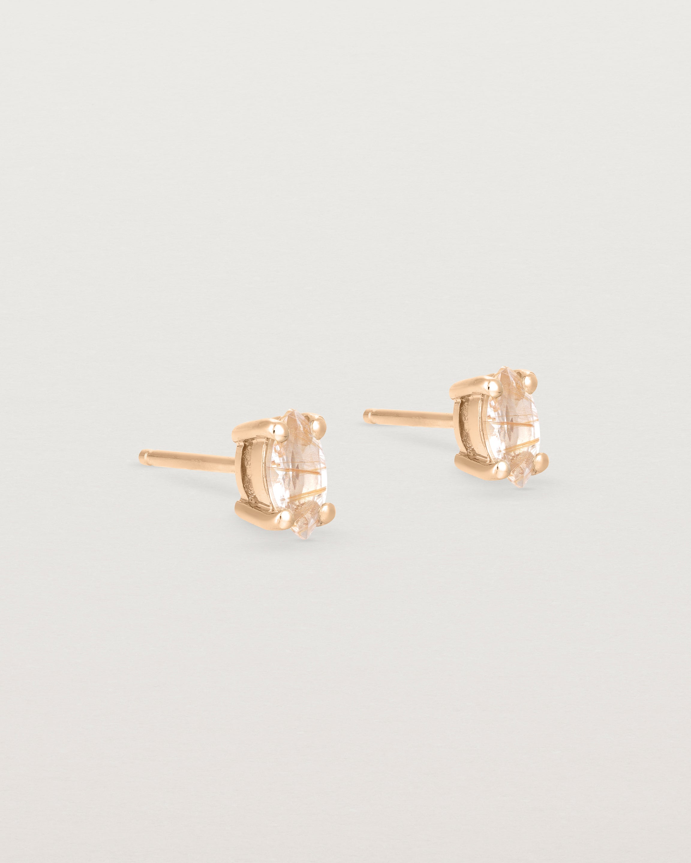A pair of rose gold studs featuring a marquise shaped light yellow rutilated quartz
