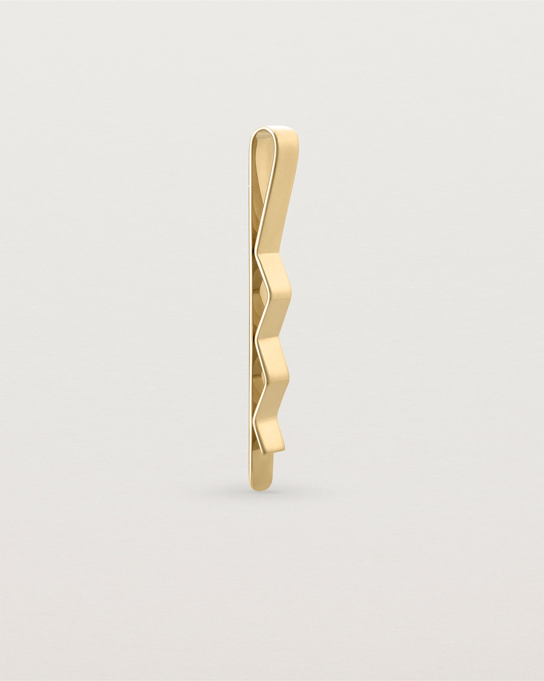 The Turas Tie Bar in Yellow Gold standing.