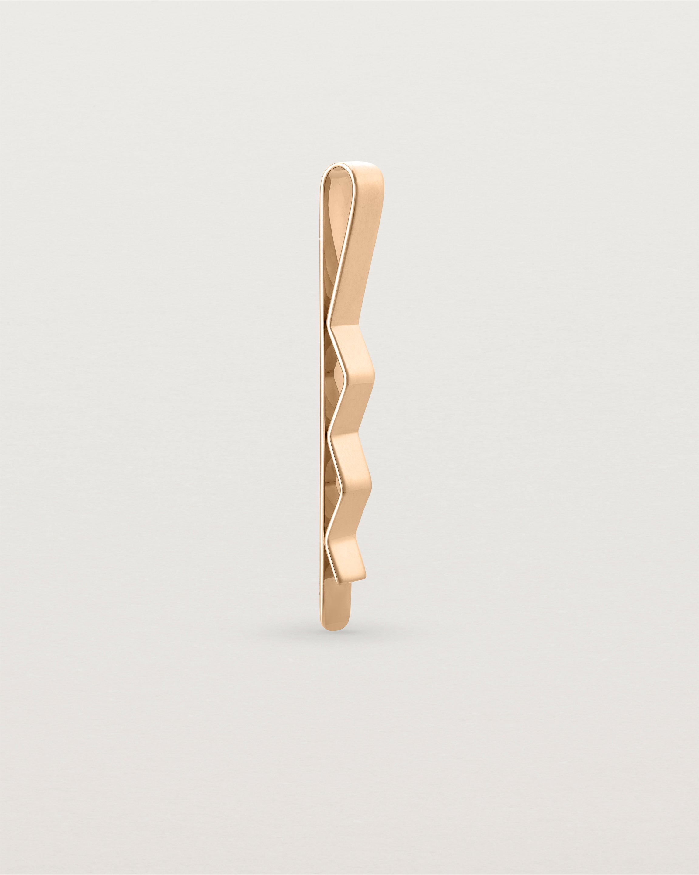 The Turas Tie Bar in Rose Gold standing.
