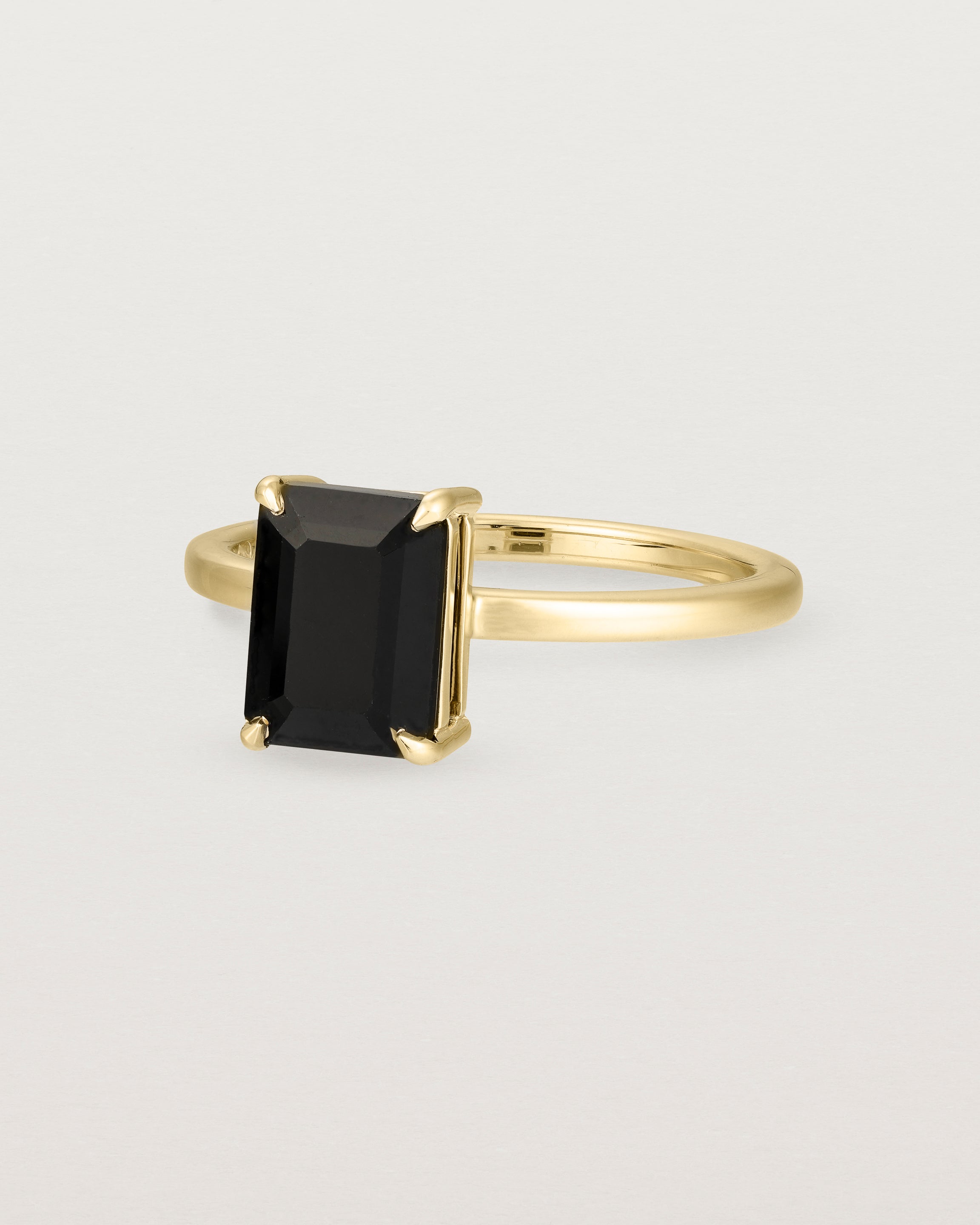 Angled view of the Una Emerald Solitaire | Black Spinel | Yellow Gold.