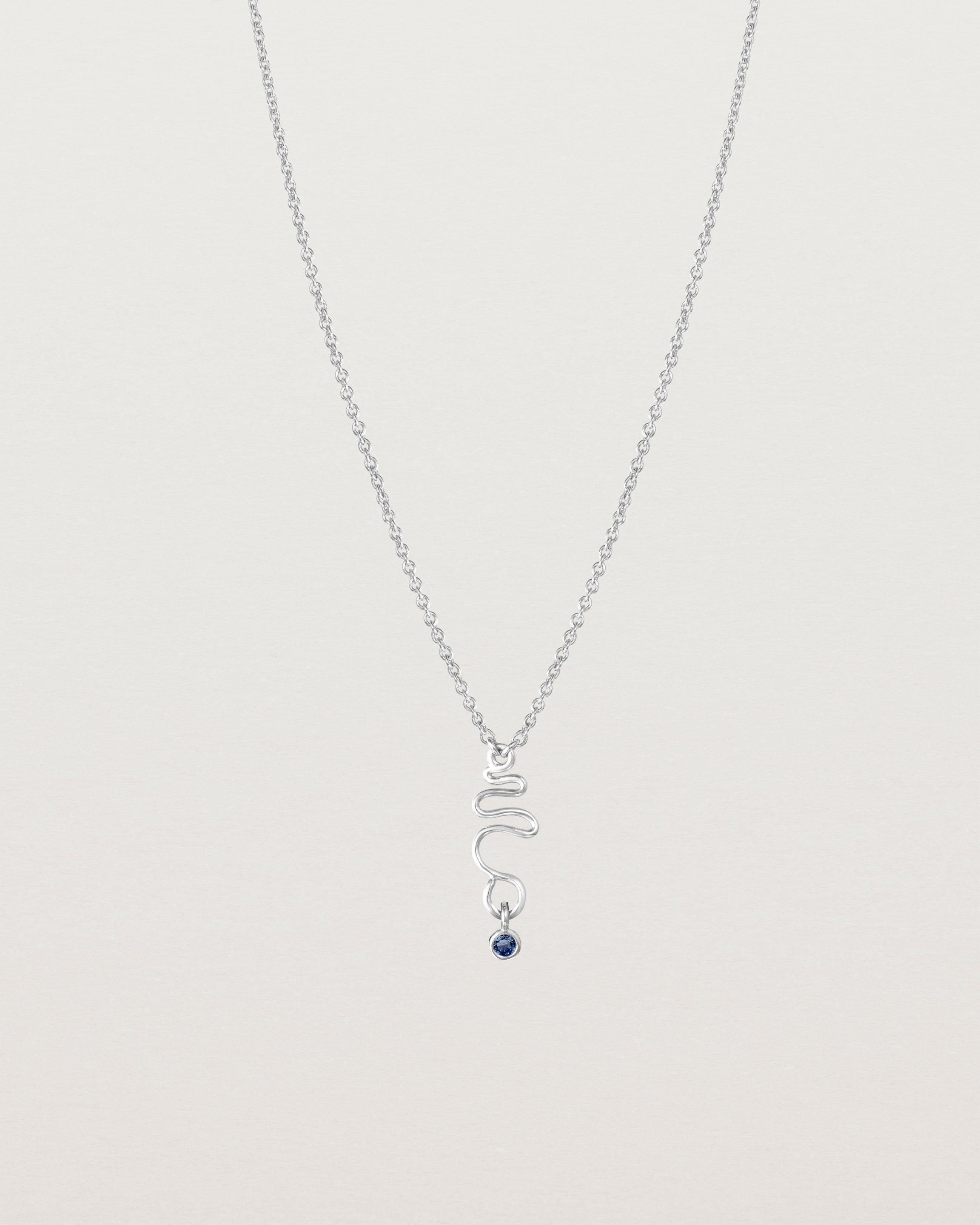 Front on deep etched image of a white gold necklace with birthstone charms.