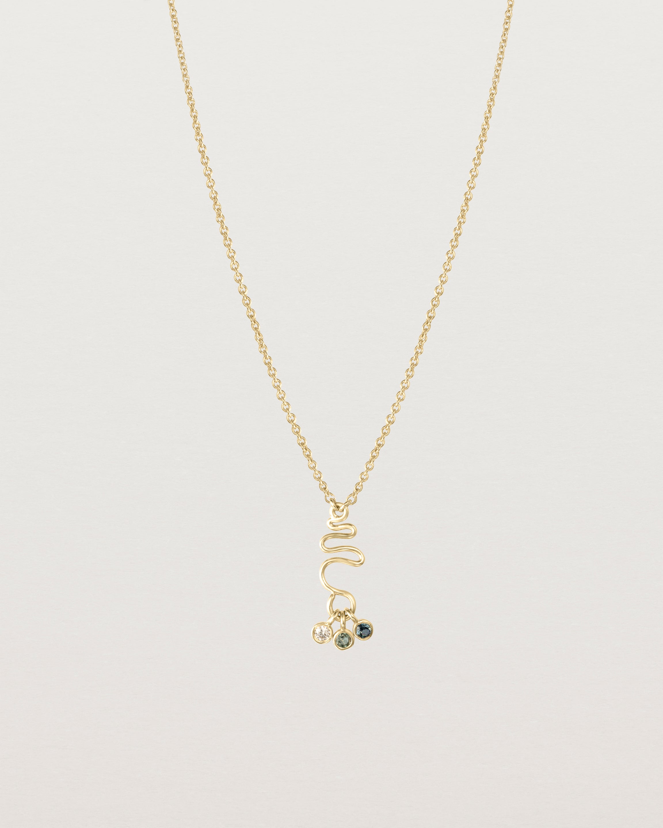 Front on deep etched image of a yellow gold necklace with birthstone charms.
