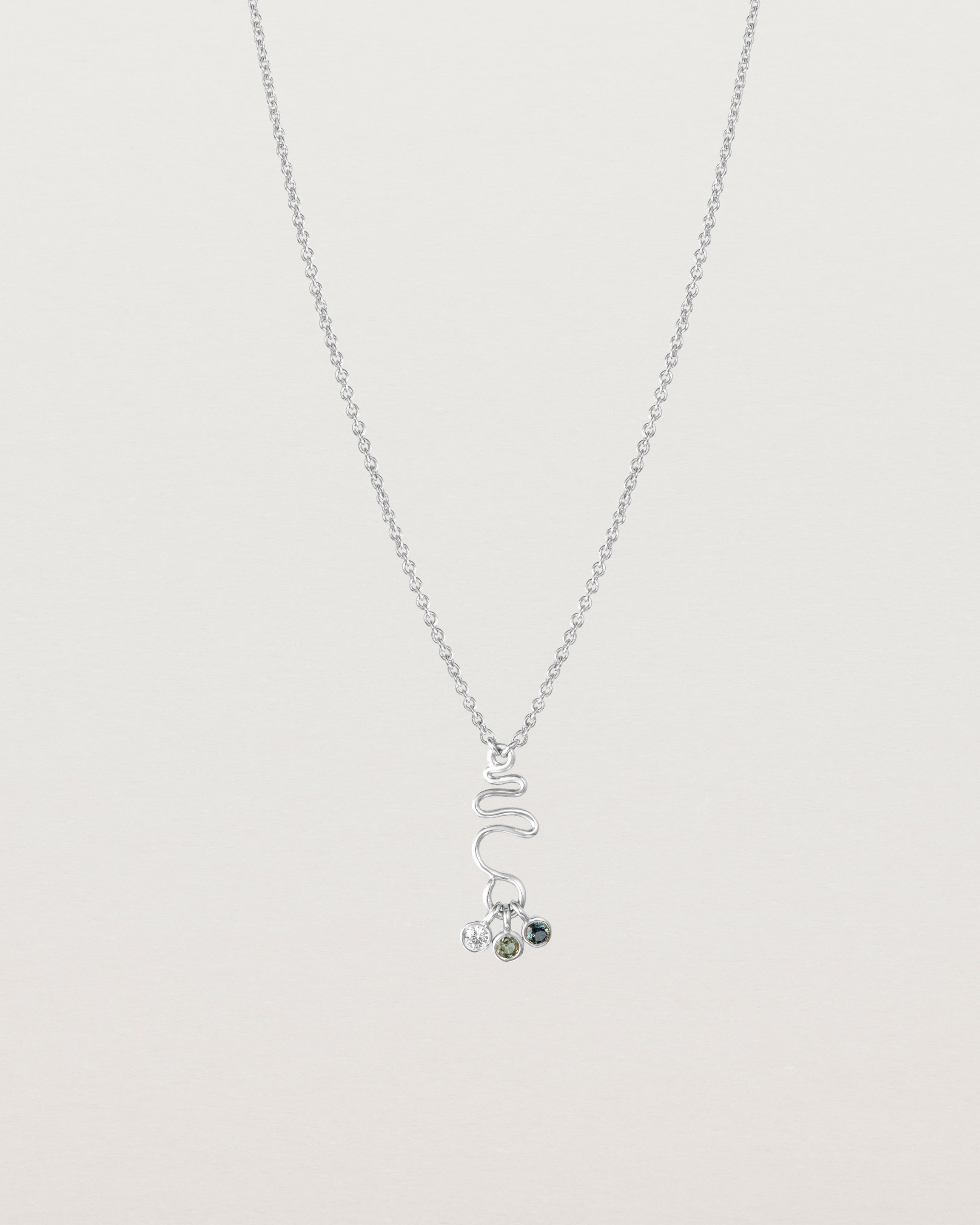 Front on deep etched image of a white gold necklace with birthstone charms.