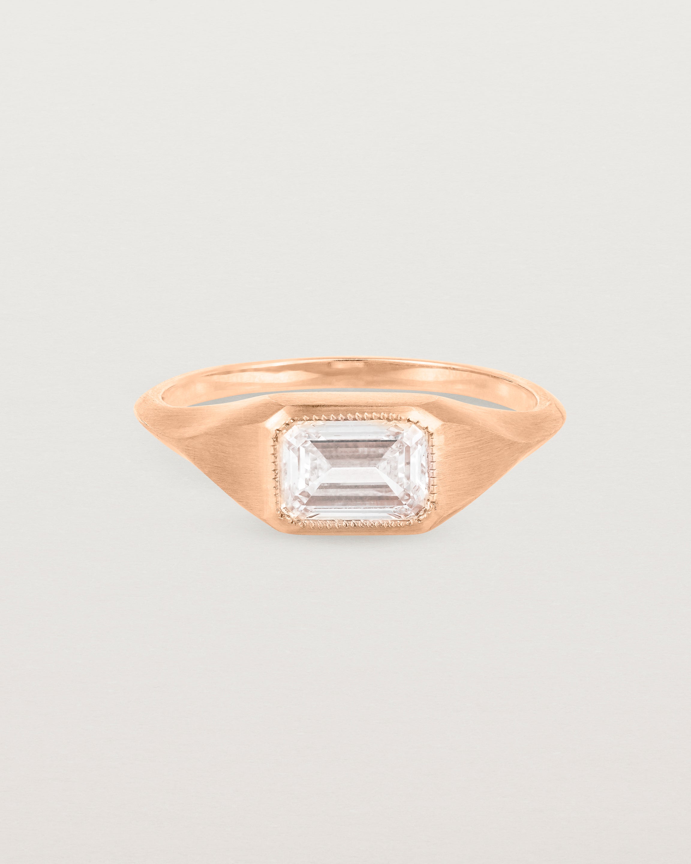 A rose gold Signet Ring featuring a emerald cut white diamond. _label: Matte Finish Example