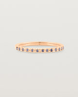 A fine rose gold wedding ring with thirteen blue sapphires