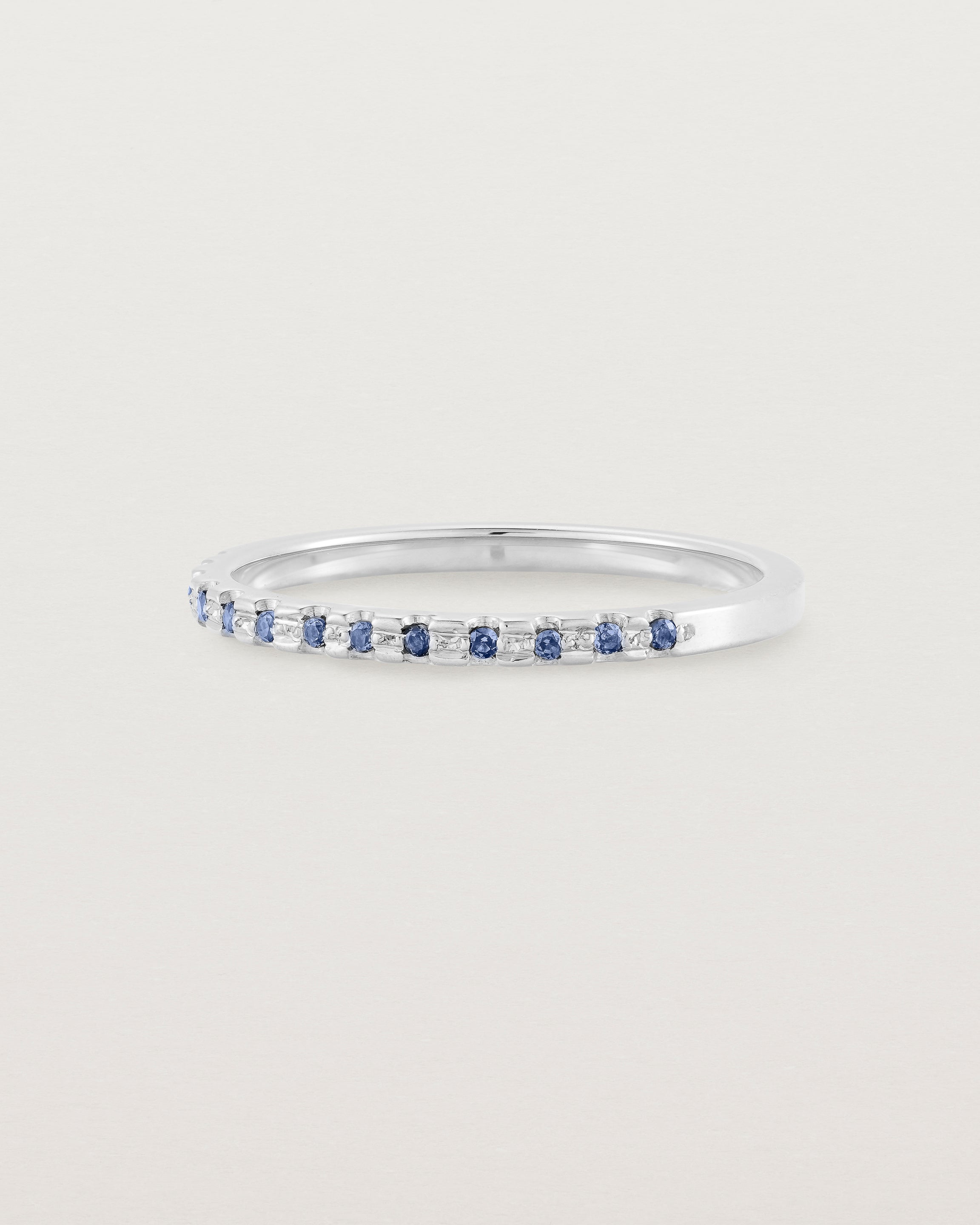 A fine white  gold wedding ring with thirteen blue sapphires