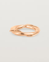 A rose gold ring featuring two entwined metal bands