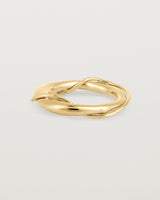 A yellow gold ring featuring two entwined metal bands