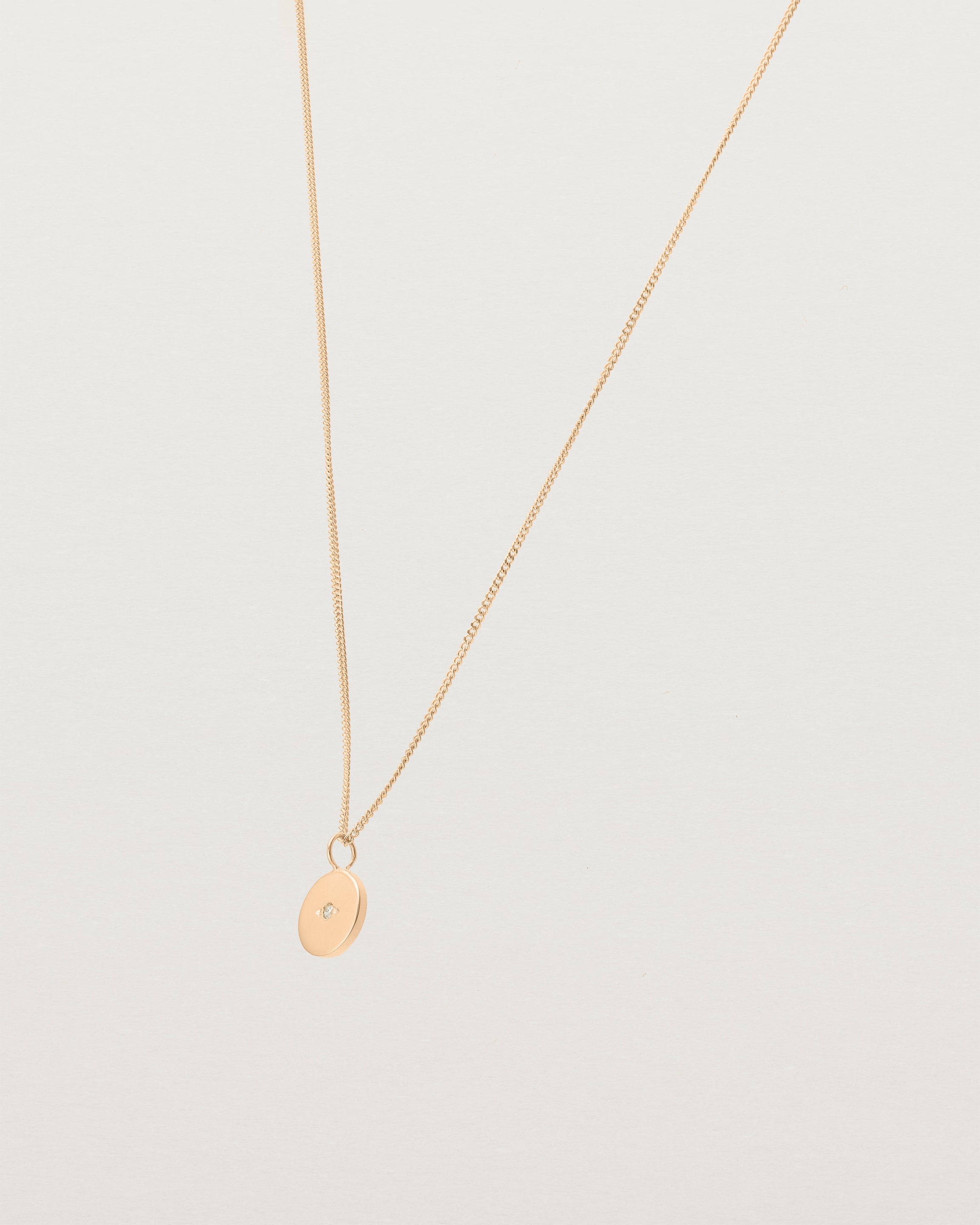 Angled view of the Eily Necklace with a diamond in rose gold.