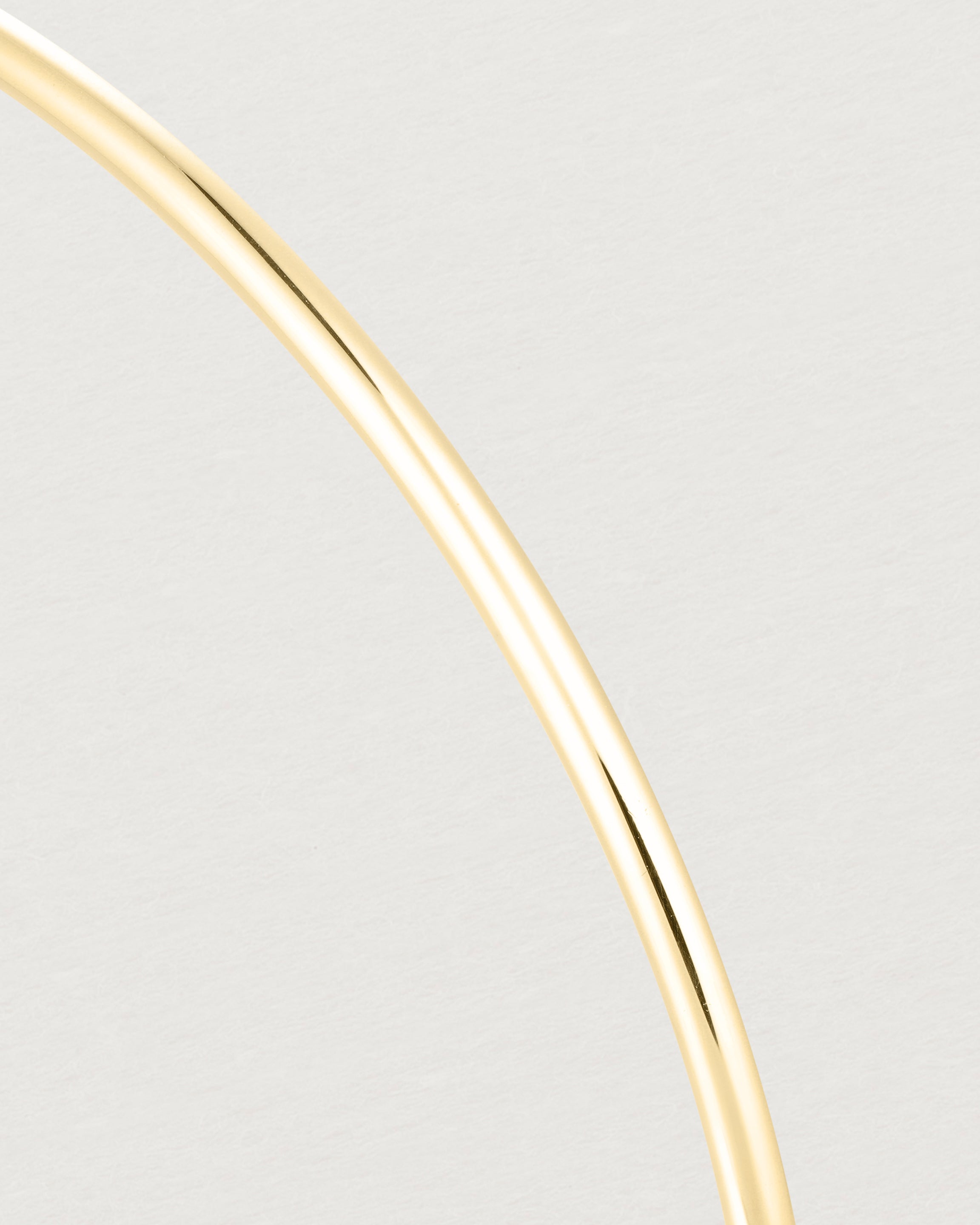 Close up of the detail of the Oval Bangle in Yellow Gold.