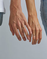 A male and female model wear the 2mm flat wedding band in yellow gold