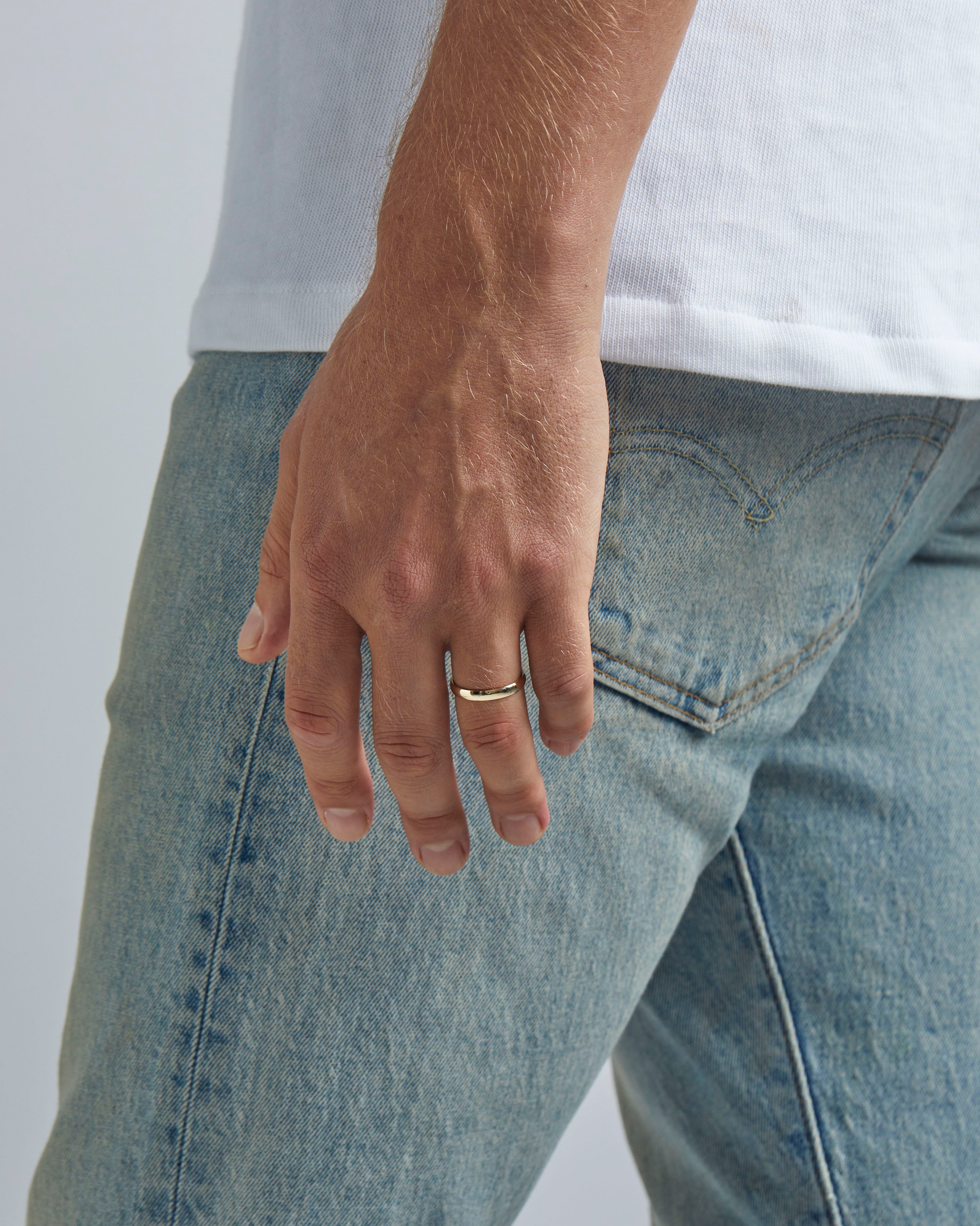A model wears our 4mm classic wedding ring in yellow gold