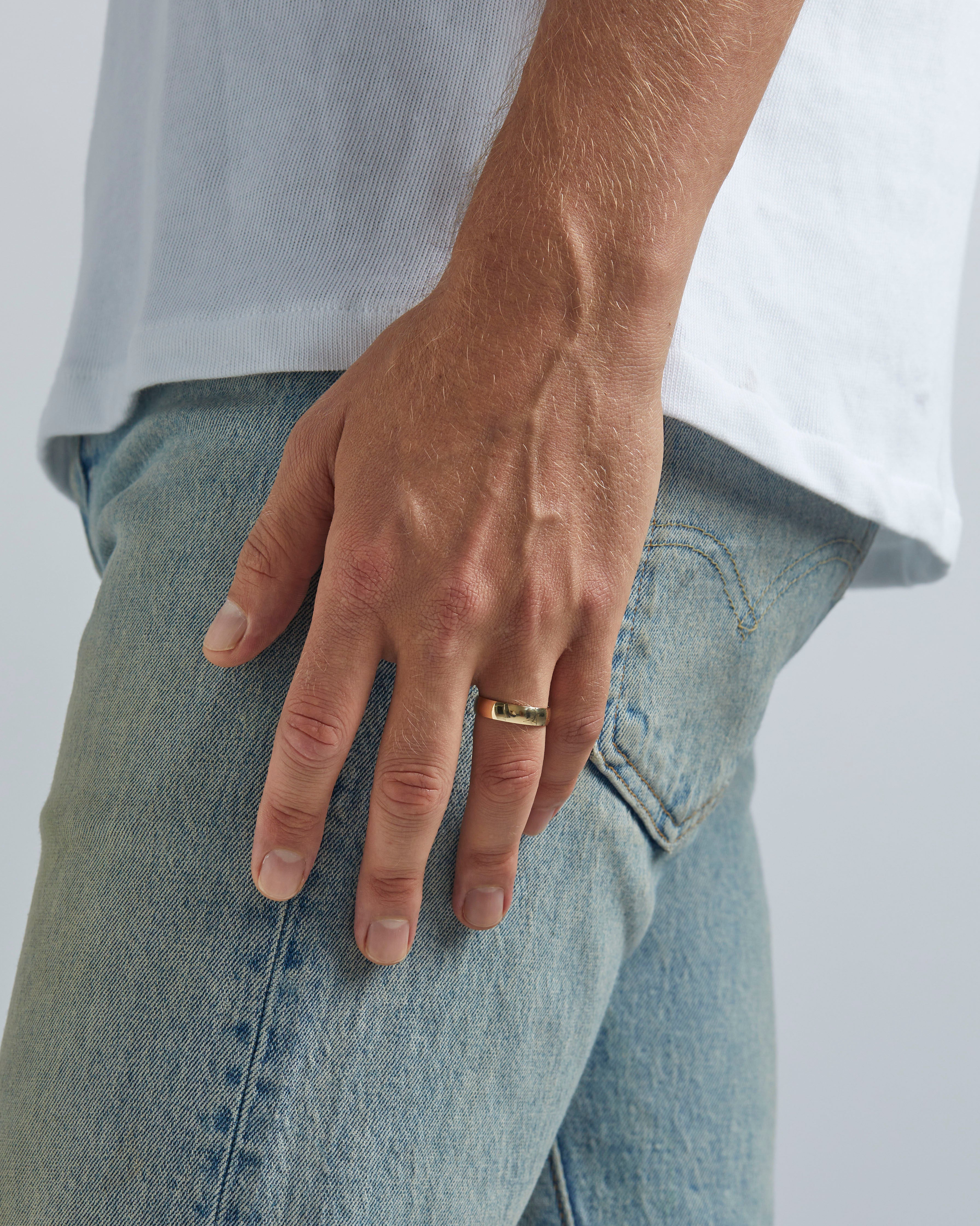 A model wears our 6mm classic wedding ring in yellow gold