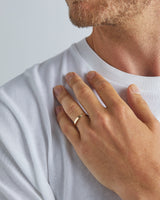 A model wears our 3mm flat wedding ring in yellow gold