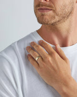 A model wears our 6mm grain wedding ring in yellow gold