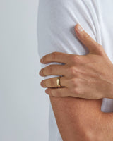 A model wears our 5mm seam wedding ring in yellow gold