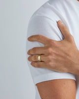 A model wears our 7mm seam wedding ring in yellow gold