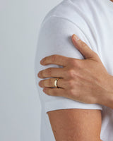 A model wears our 5mm classic heavy wedding ring in yellow gold