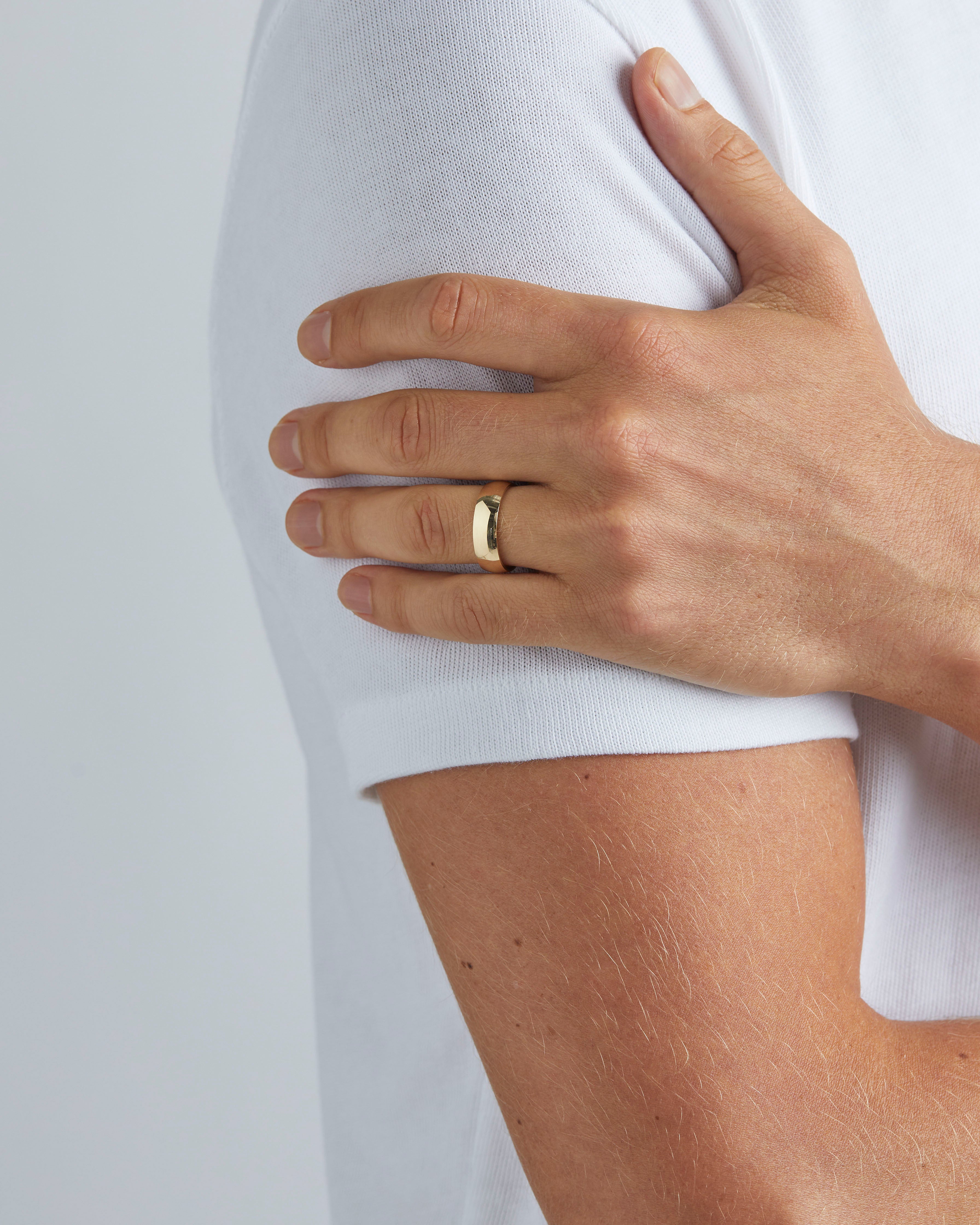 A model wears our 6mm classic heavy wedding ring in yellow gold