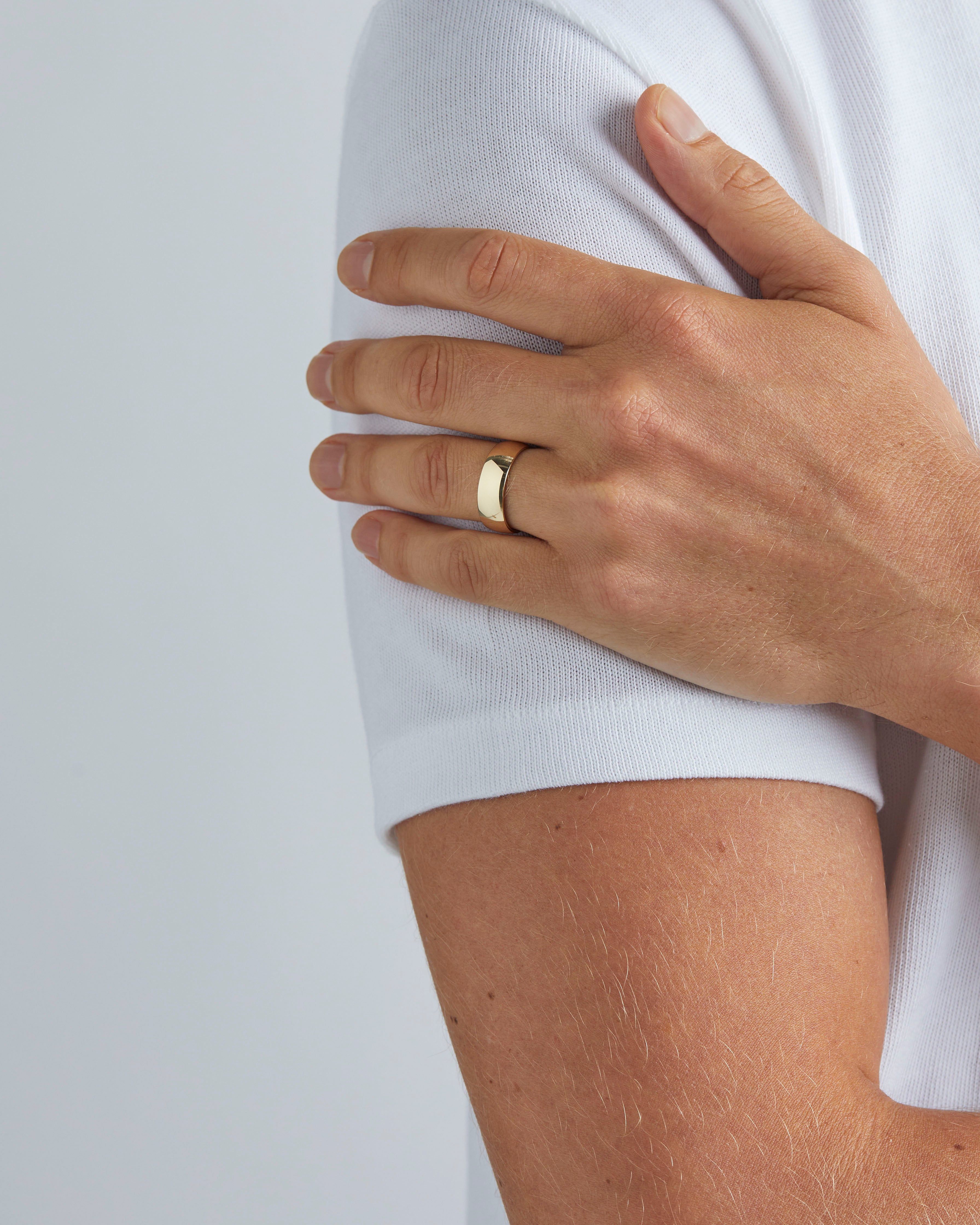 A model wears our 7mm classic heavy wedding ring in yellow gold