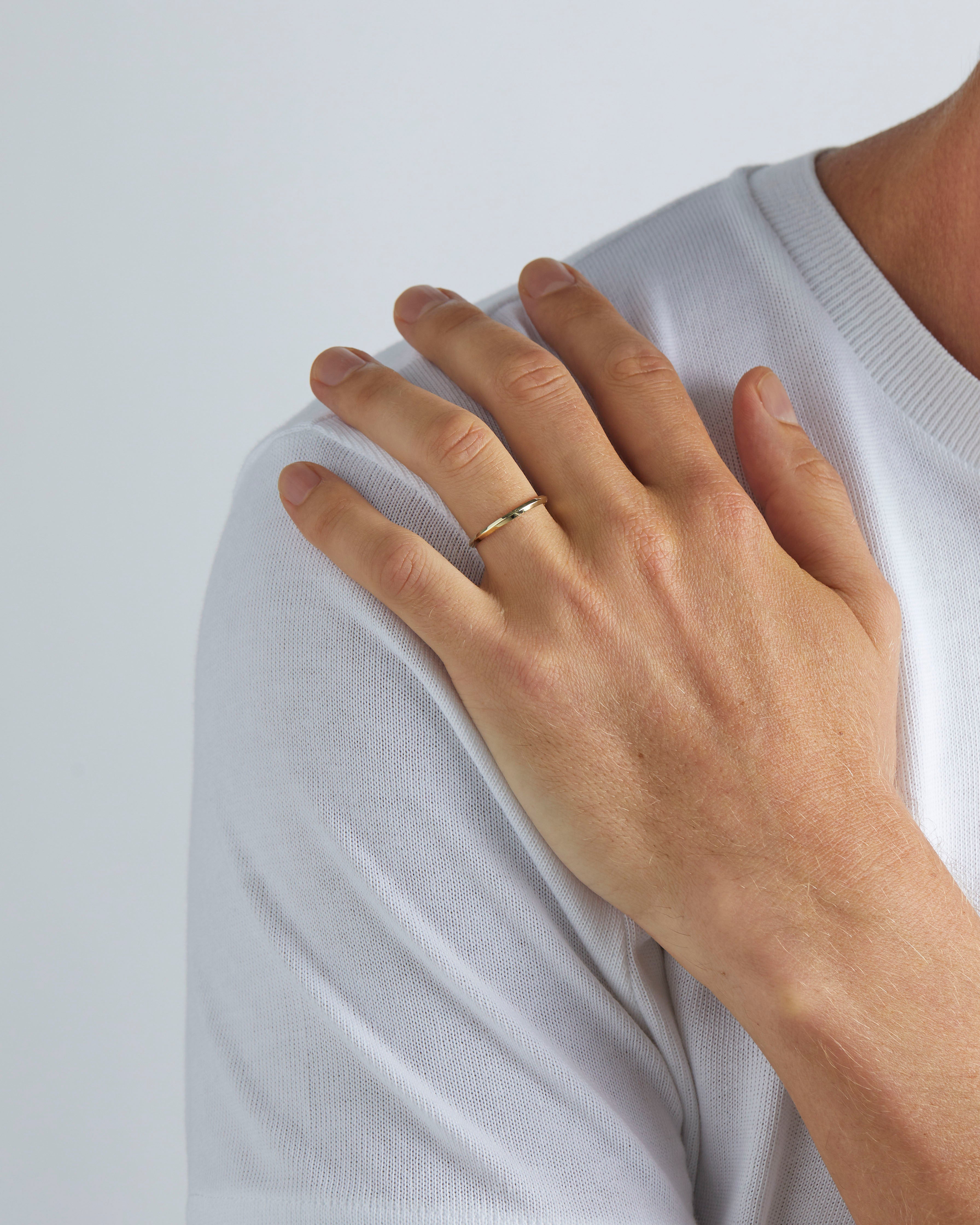 A model wears our 2mm knife edge wedding ring in yellow gold