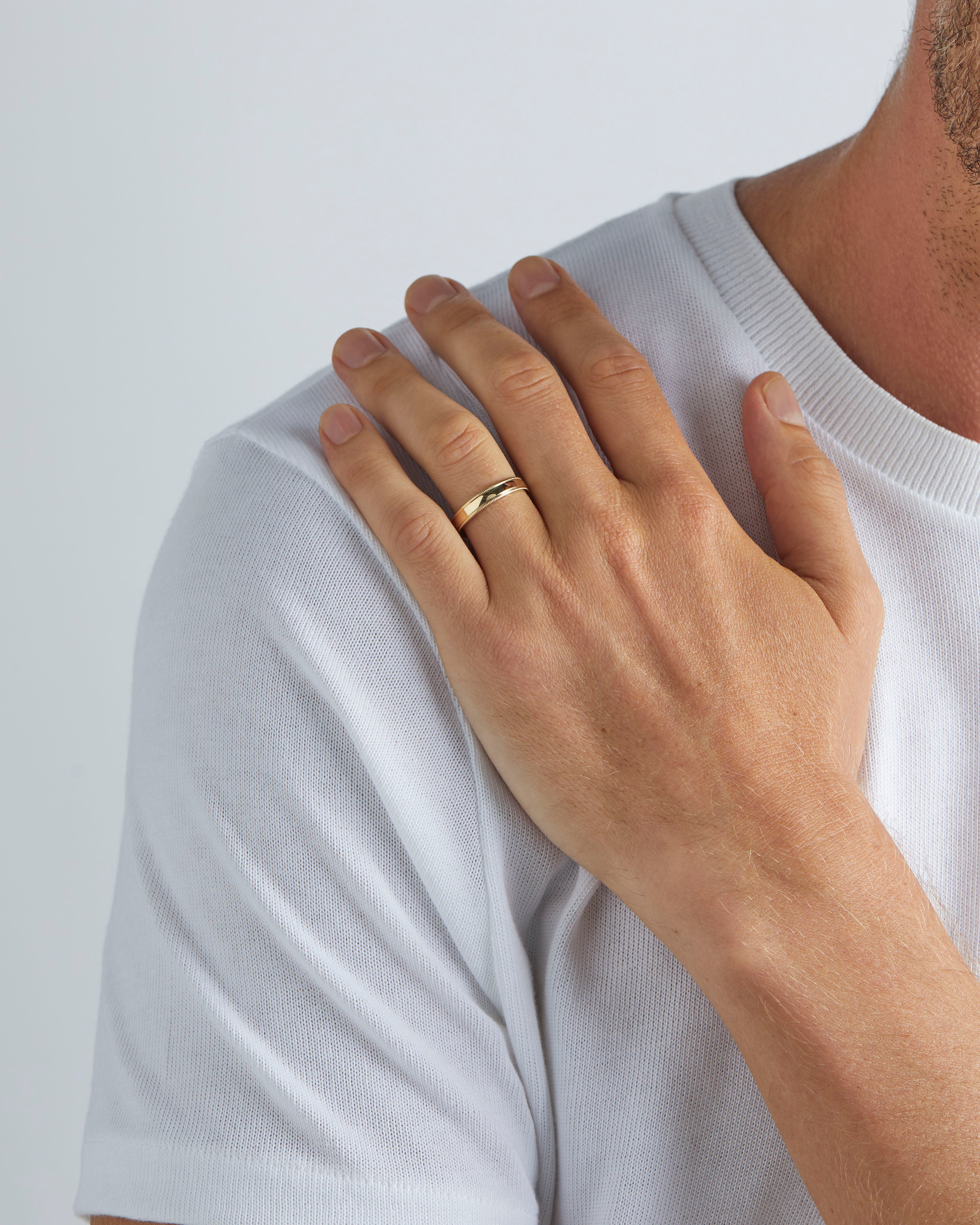 Male wearing a 4mm Thick Millgrain Wedding Ring, in Yellow Gold. 