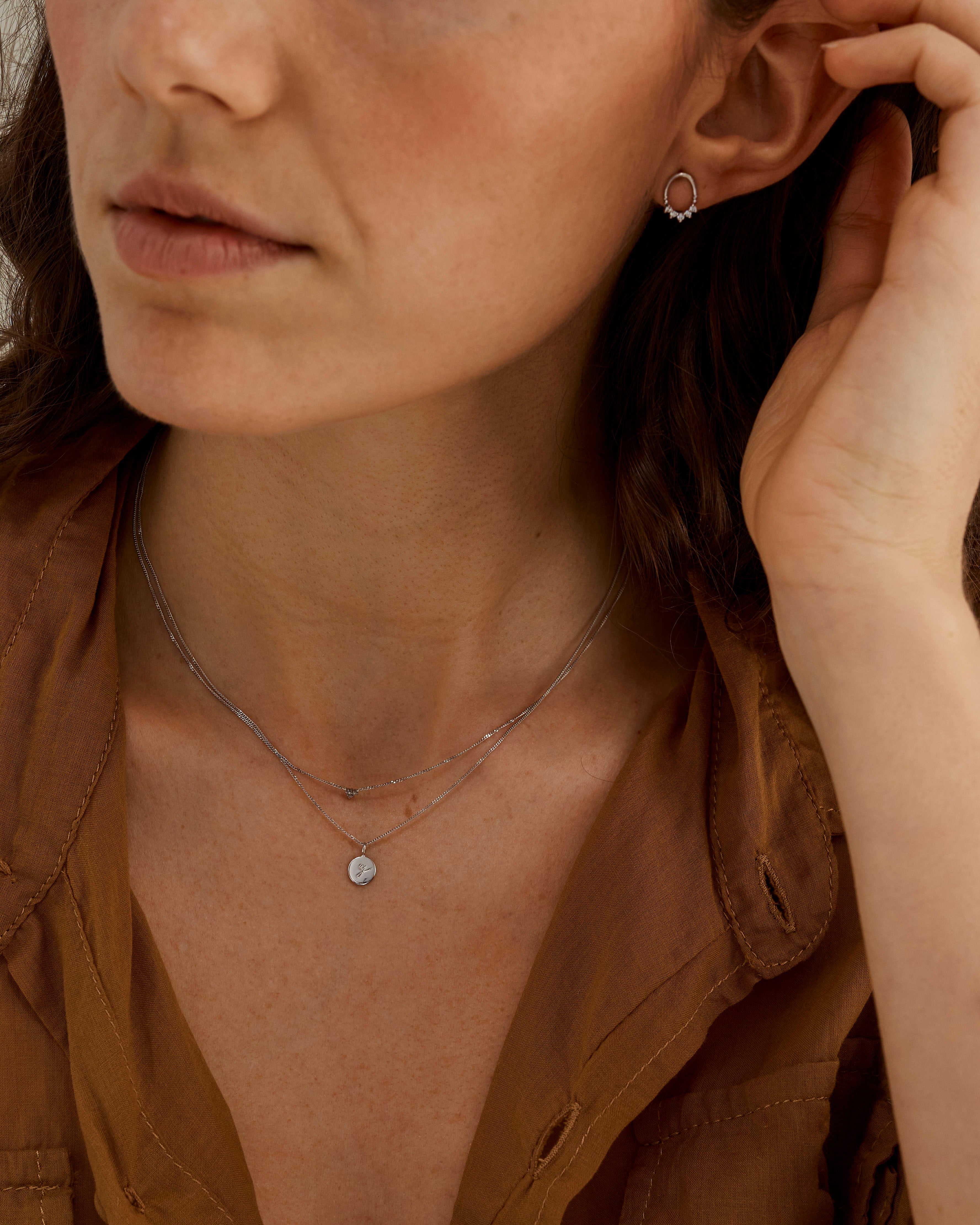 A woman wearing a necklace stack, including the Mae Necklace in Silver.