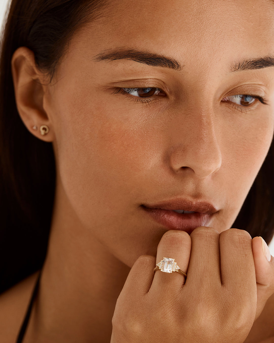A model wears our vintage inspired emerald cut morganite ring with diamond set shoulders either side
