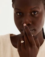 A model wears our oval rutilated quartz engagement ring, adorned with white diamonds either side