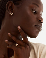 A model wears our emerald cut morganite engagement ring, adorned with white diamonds either side