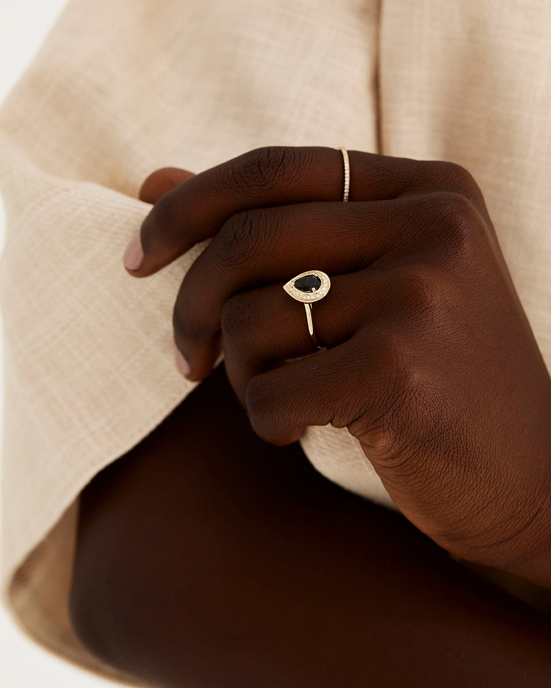 A model wears a pear cut Australian sapphire halo engagement ring 