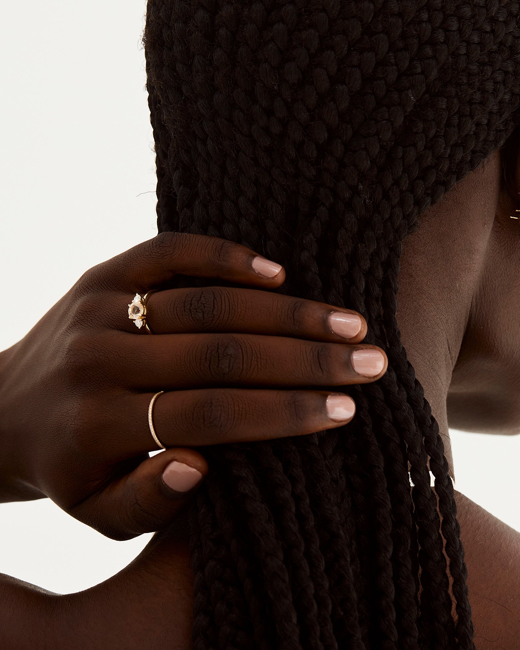 A model wears a round trio style engagement ring with a morganite surrounded by white diamond either side