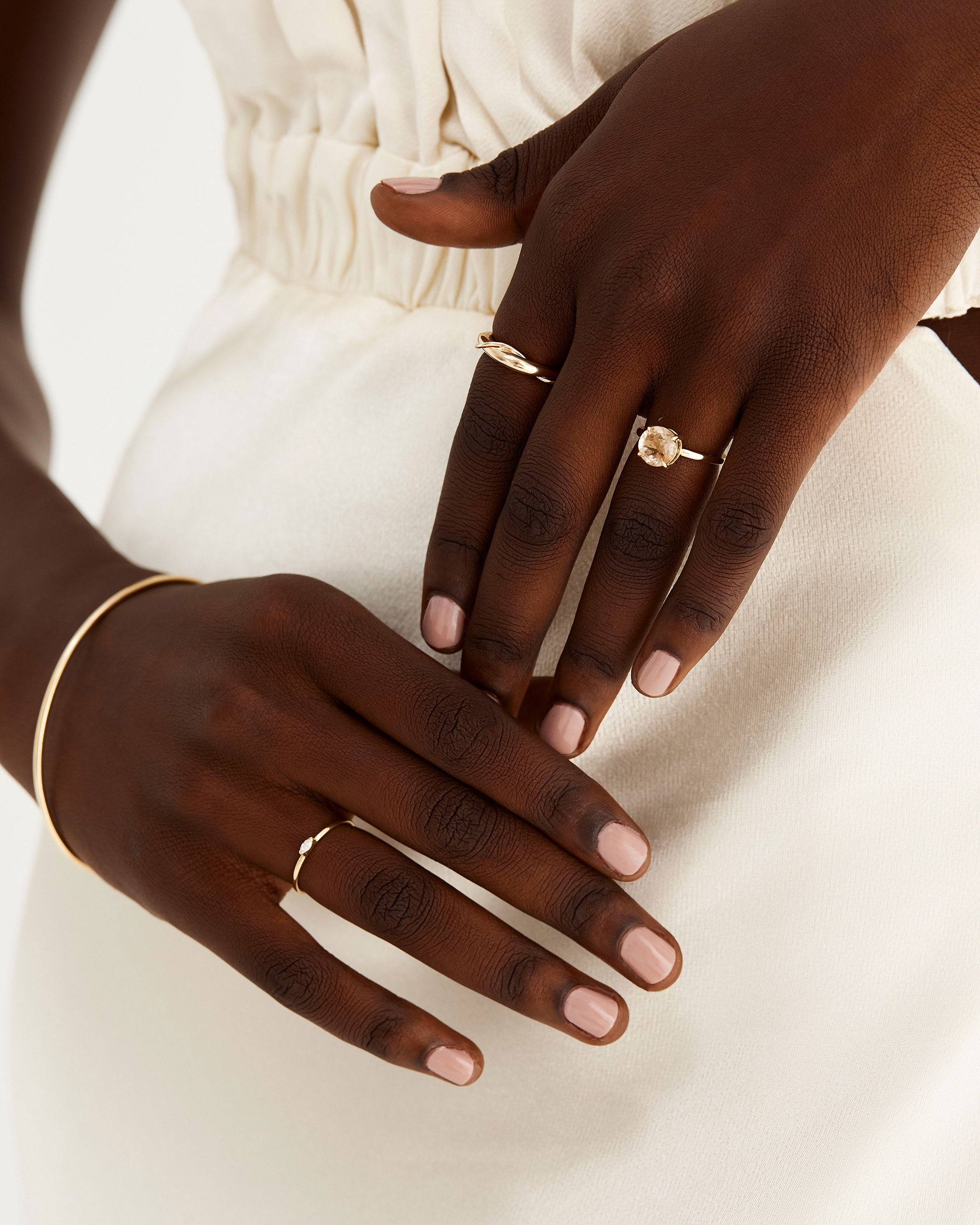 A model wears our petite diamond marquise ring in yellow gold, worn with NMJ classics