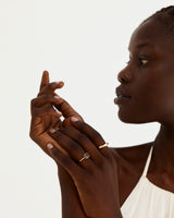 A model wears a round solitaire featuring an 8mm tourmalinated quartz