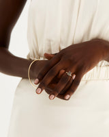 A model wears an emerald cut solitaire featuring a tourmalinated quartz