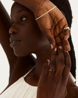 A model wears an emerald cut solitaire featuring a opaque black spinel