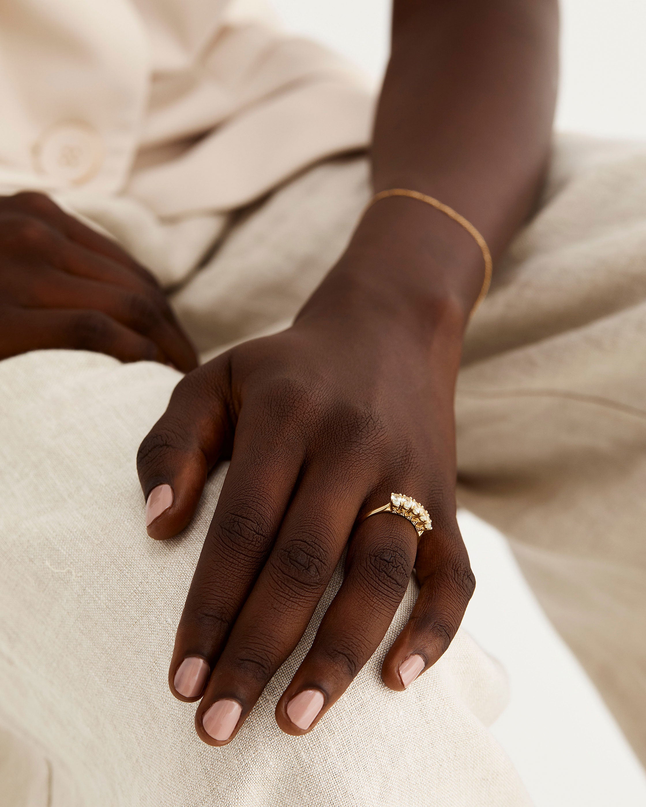 A model wears an oval wrap ring featuring green amethyst 