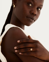 A model wears a round solitaire with a savannah sunstone and diamond details in the setting