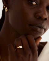 A model wears a emerald cut white diamond set in a traditional signet style