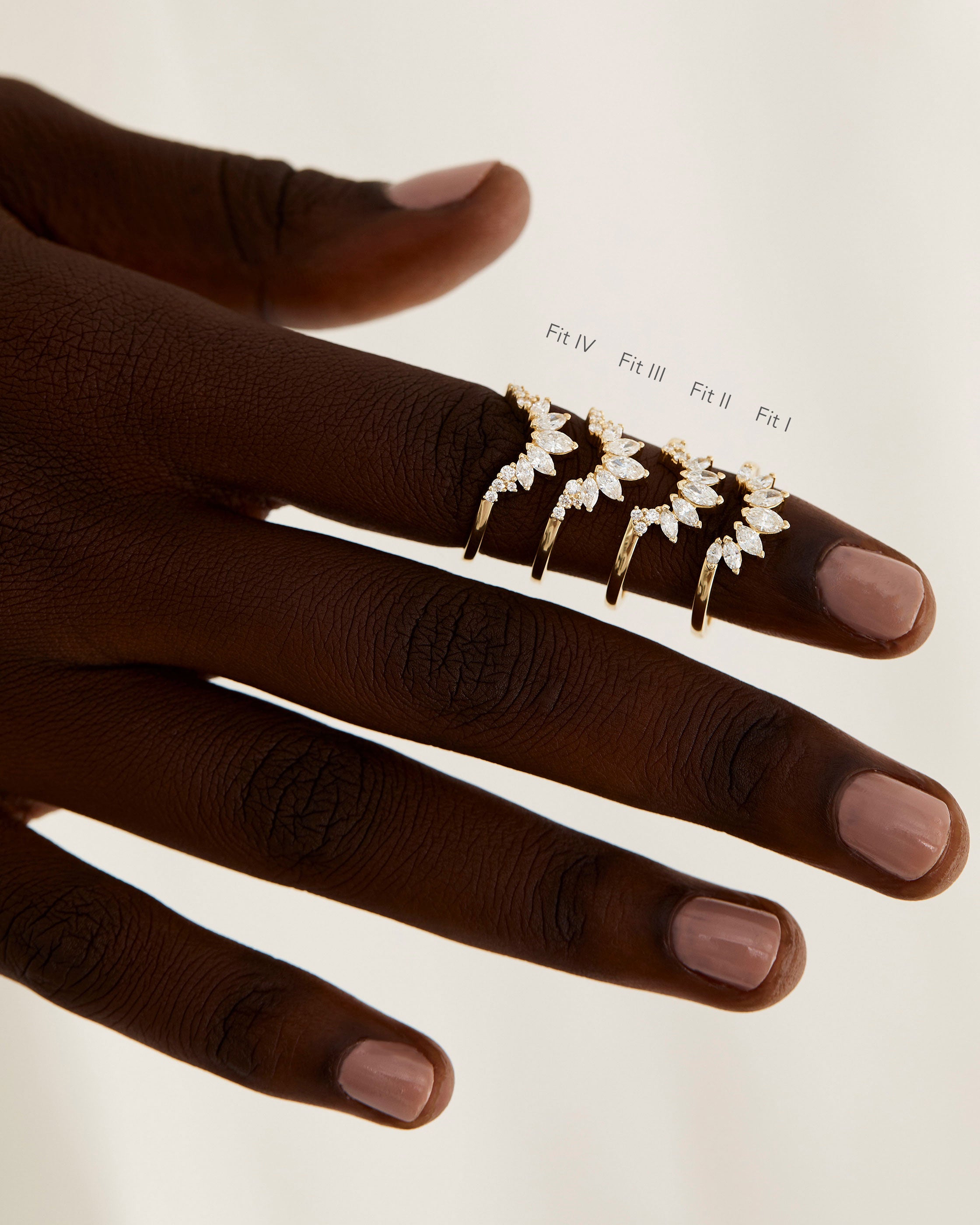 A model shows the four different sizes of a diamond sun inspired crown ring.