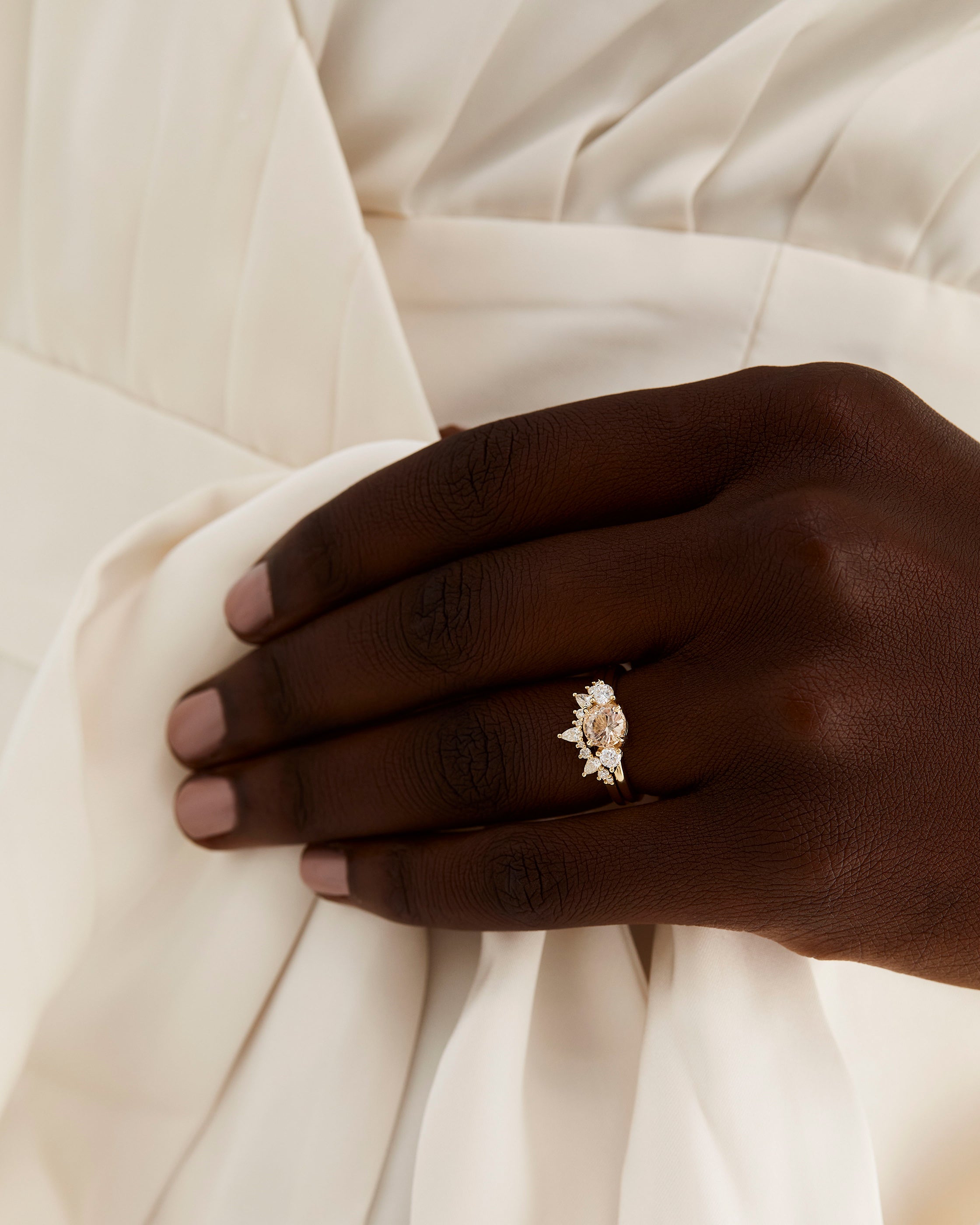 A model wears a diamond crown ring stacked with a trio style engagement ring