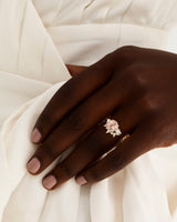 A model wears a diamond crown ring stacked with a trio style engagement ring