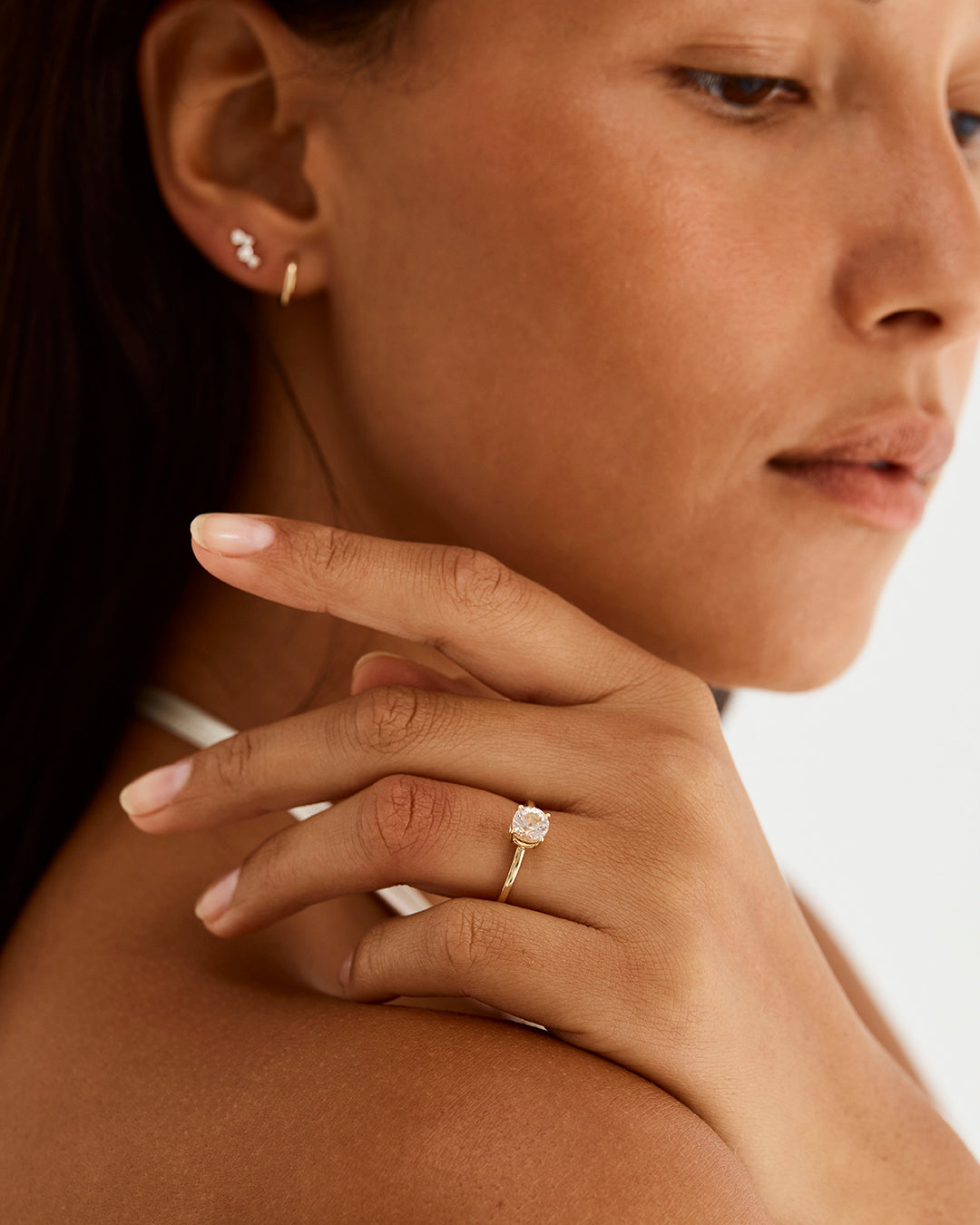 A model wearing a round solitaire style engagement ring featuring a morganite. 