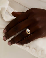 A model wears a dot detailed crown ring stacked with a solitaire style engagement ring.