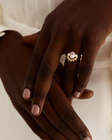 A model wears a dot detailed crown ring stacked with a solitaire style engagement ring.