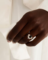 A model wears a diamond sun inspired crown ring stacked with a trio style engagement ring.
