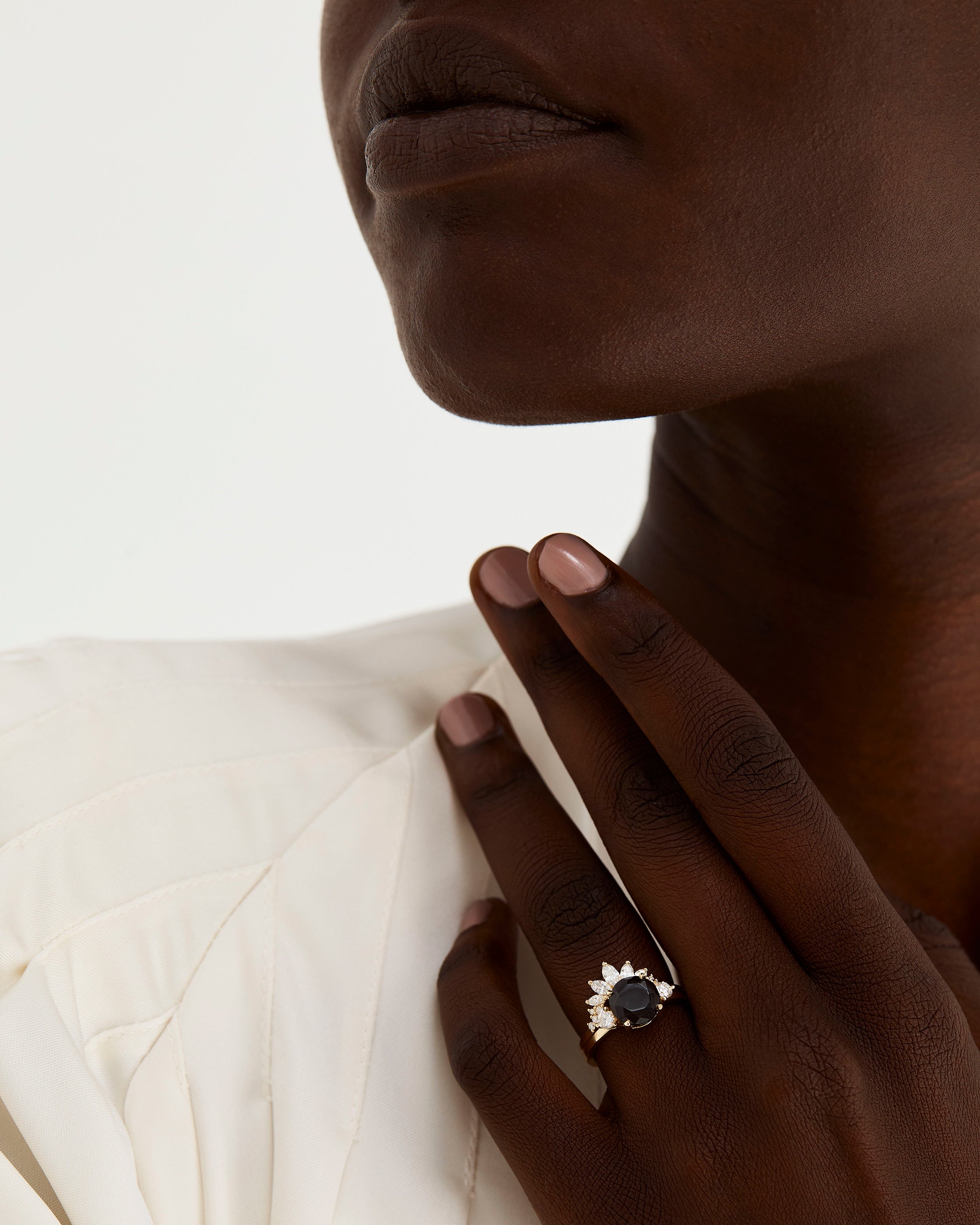 A model wears a diamond sun inspired crown ring stacked with a trio style engagement ring.